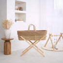 Biscuit brown Organic Knitted Palm Moses Basket on natural folding stand in a white ultra stylish minimalist nursery next to an organic play mat and wooden play gym on the floor | Moses Baby Baskets, Bassinets | Organic Baby Essentials | Nursery Furniture - Clair de Lune UK