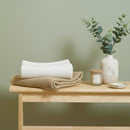 Cream and biscuit Organic Knitted Baby Blankets folded on an oak table in the nursery | Cosy Baby Blankets & Swaddles | Nursery Bedding | Newborn Baby Essentials - Clair de Lune UK