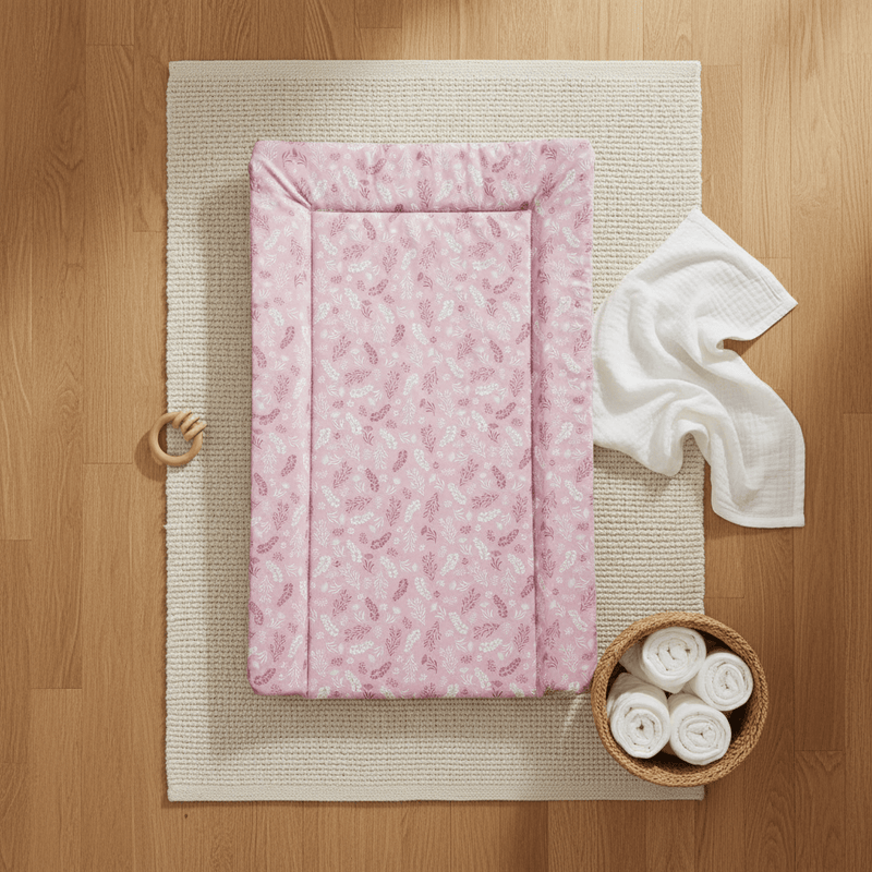 Flat lay of the East Coast Pink Posie Changing Mat on an oak floor with white muslin and nappies | Bathing & Changing Essentials - Clair de Lune UK