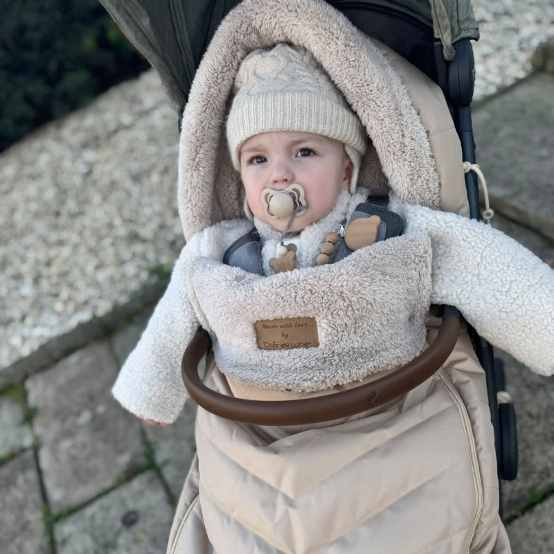 Toddler Wrapped up in the Beige Snug Universal Pushchair Footmuff on a winter stroll | Pushchair Accessories - Clair de Lune UK