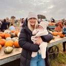 Mum and baby at the pumpkin patch on an autumn day wearing the Oatmeal brown Star Baby Wrap Blanket | Cosy Baby Blankets | Swaddle Blanket | Nursery Bedding - Clair de Lune UK