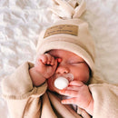 Newborn baby girl rubbing her eyes wearing the oatmeal star fleece baby wrap blanket getting ready for an outdoor adventure | Cosy Baby Blankets | Swaddle Blanket | Nursery Bedding - Clair de Lune UK