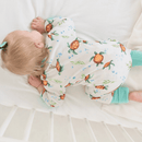 Baby girl sleeping on her tummy wearing the GrowGrows Organic Tropical Turtles Sleepsuit | Baby Grows and Onesies | Organic Baby Clothes - Clair de Lune UK