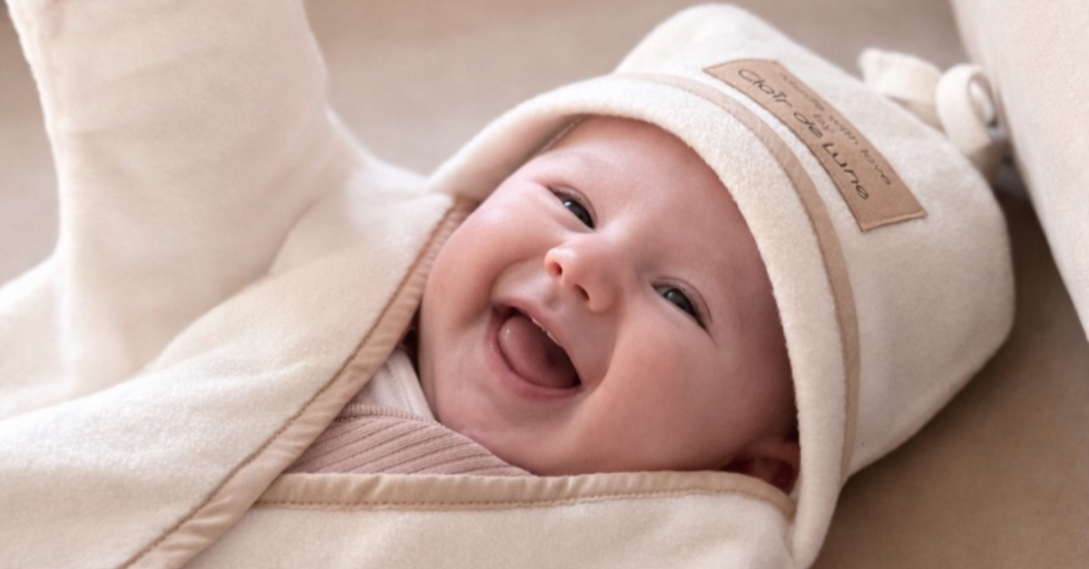 Baby Laughing while wearing the Star Fleece Baby Wrap Blanket with Hood | Baby Blankets and Swaddles | Newborn Travel Essentials - Clair de Lune UK