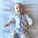 Baby lying on a white sheet wearing the GrowGrows Organic Up, Up & Away Sleepsuit with key features | Baby Grows and Onesies | Organic Baby Clothes - Clair de Lune UK
