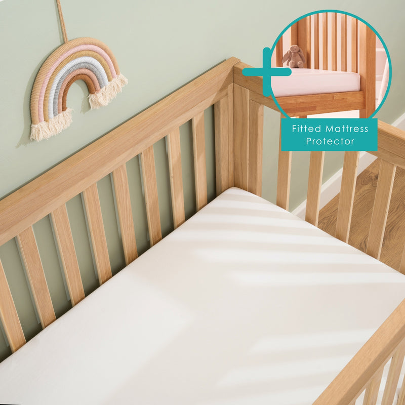  2 Pack White Fitted Cotton Cot Sheets - 120 x 60 cm on a cot mattress in the oak cot bed bundled with a mattress protector | Soft Baby Sheets | Cot & Cot Bed Bedding | Nursery Linen - Clair de Lune UK