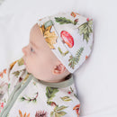 Baby lying in bed wearing the Woodland Walks Baby Hat with woodland forest print made from bamboo and organic cotton from GrowGrows and matching sleepsuit | Bamboo Babywear - Clair de Lune UK