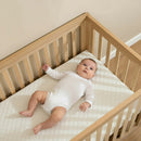 Baby sleeping on the Essentials Hypoallergenic Fibre Cot Bed Mattress (140 x 70 cm) in the Solid Oak Cot Bed | Cot Bed Mattresses (140x70cm) | Baby & Toddler Mattresses | Bedding | Nursery Furniture - Clair de Lune U