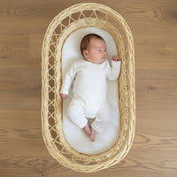 Baby lying on the Hypoallergenic Wicker Moses Basket Mattress in a wicker basket | Moses Basket Mattresses | Moses Baby Basket Accessories | Nursery Bedding - Clair de Lune UK