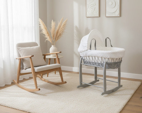 Dimple Grey Wicker Moses Basket with Stand and Bedding Bundle next to a nursery chair in the baby room | All Moses Baskets | Bassinets - Clair de Lune UK