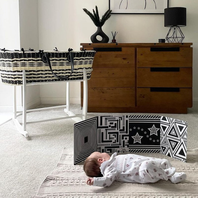 Baby sleeping next to the Black & Cream Sustainable Moses Basket on the white Deluxe rocking stand | Moses Baskets and Stands | Co-sleepers | Nursery Furniture - Clair de Lune UK