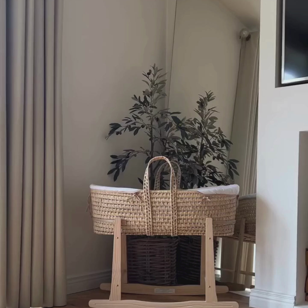 Mum lifting her newborn out of the Organic Palm Moses basket with Rocking Stand in Cream | Moses Baby Baskets & Bassinets - Clair de Lune UK