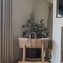 Mum lifting her newborn out of the Organic Palm Moses basket with Rocking Stand in Cream | Moses Baby Baskets & Bassinets - Clair de Lune UK