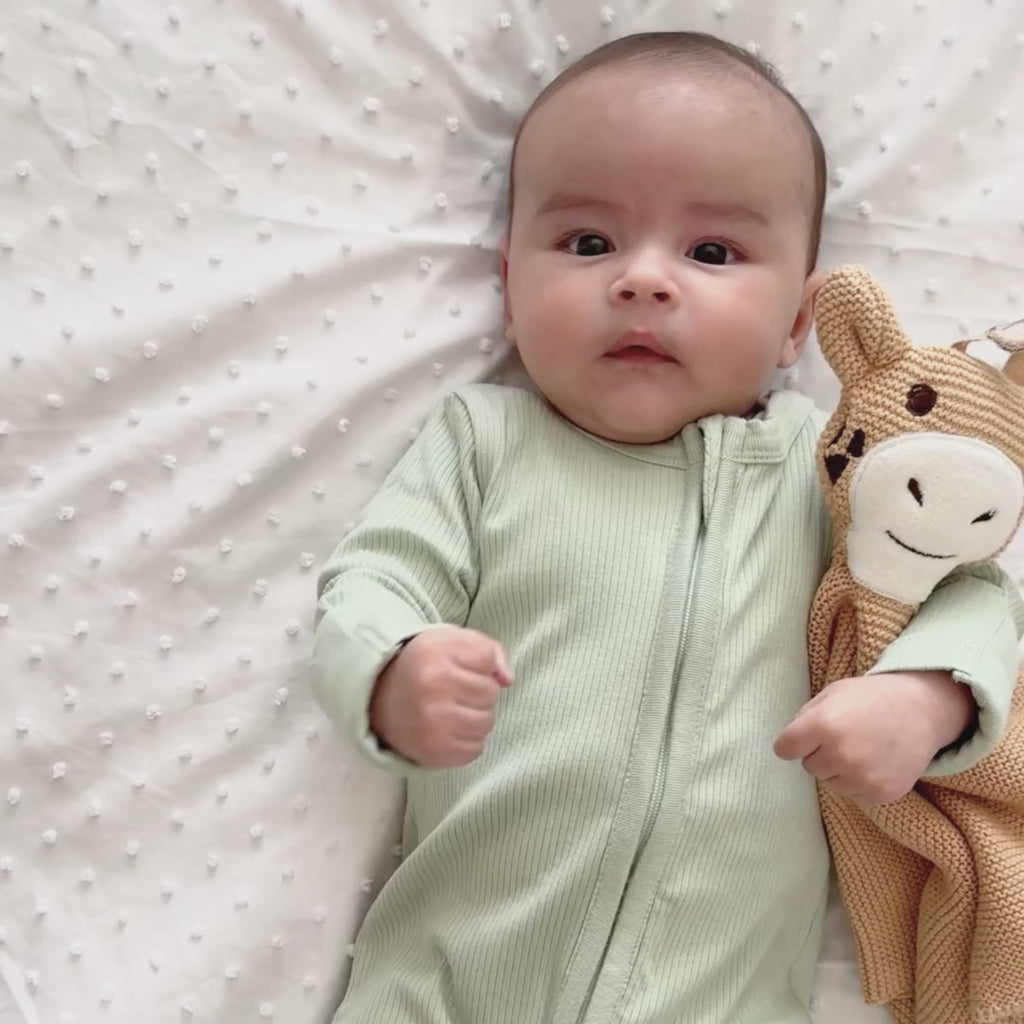 Newborn wearing the Sage Grow Grows Organic Ribbed Baby Sleepsuit and cuddling with the giraffe Organic Comforter | Baby Sleep Wear | Children's pyjamas - Clair de Lune UK