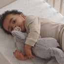 Baby relaxing and playing in the Cot Bed part of the Cashmere CuddleCo Clara 3 Piece Nursery Furniture Set in a cosy neutral nursery | Nursery Furniture | Cot Bed - Clair de Lune UK