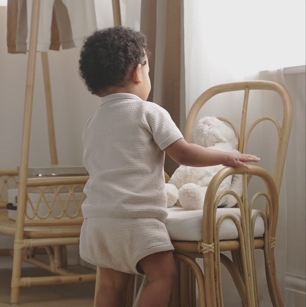 Boy sitting on the CuddleCo Aria Toddler Chair in a neutral brown luxury nursery cuddling with a bunny toy | Toddler Furniture | Children's Chair - Clair de Lune UK