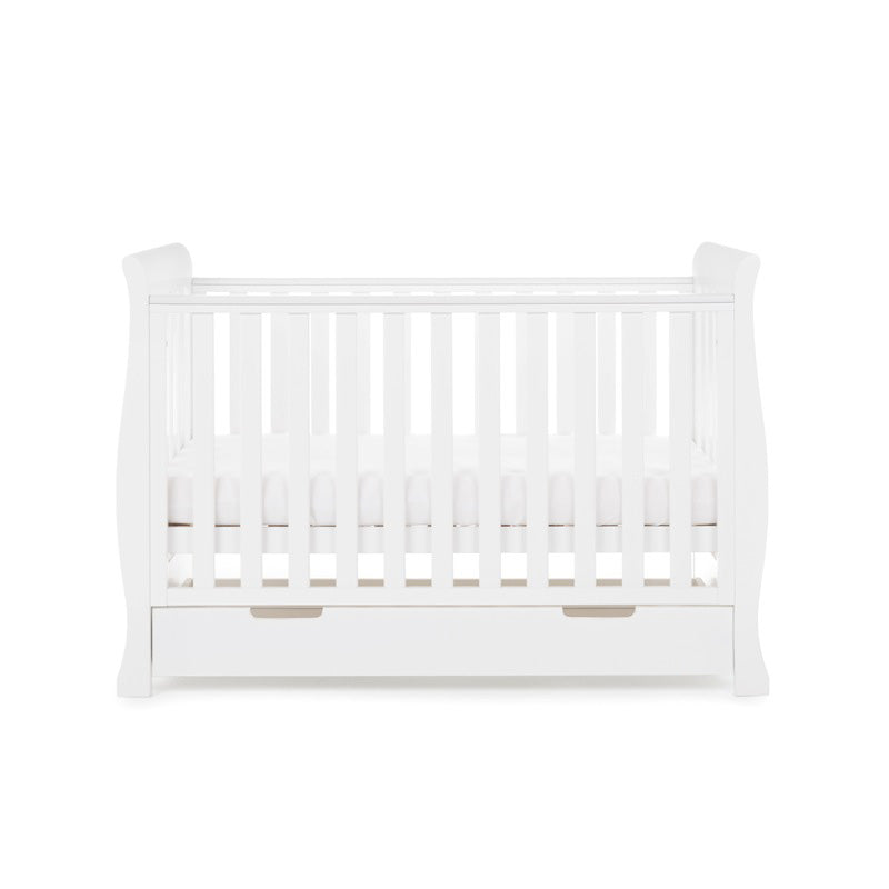 The white Obaby Stamford Mini Sleigh Cot Bed with an adjustable platform at a medium level | Cots, Cot Beds, Toddler & Kid Beds | Nursery Furniture - Clair de Lune UK