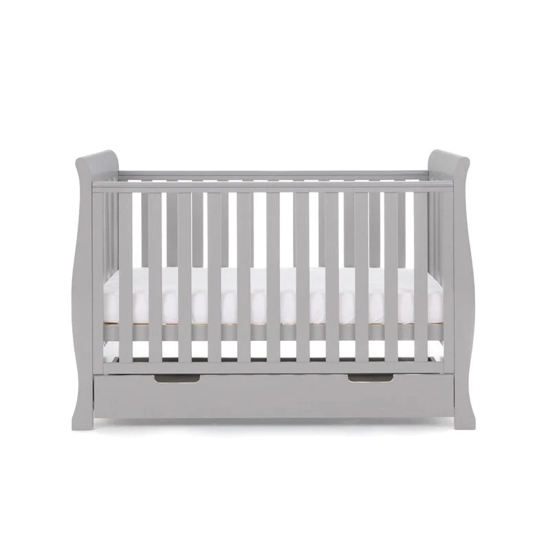 The cot bed of the Warm Grey Obaby Stamford Mini 3 Piece Room Set with the adjustable platform on the medium level | Nursery Furniture Sets | Room Sets | Nursery Furniture - Clair de Lune UK
