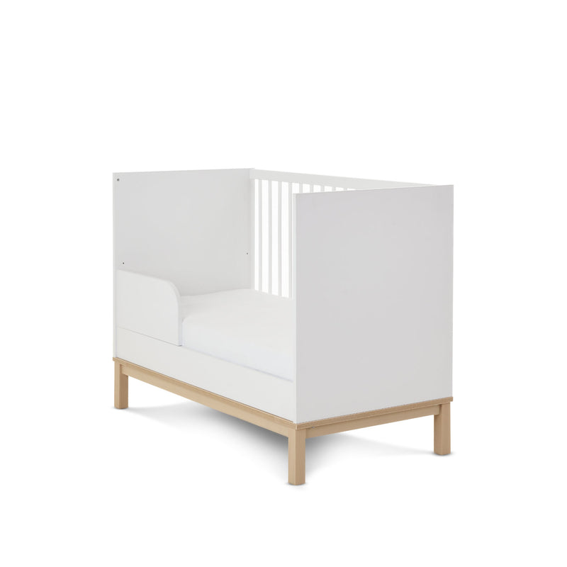 The side of the white and natural Obaby Astrid Mini Cot Bed when transformed to a toddler bed with a toddler rail | Cots, Cot Beds, Toddler & Kid Beds | Nursery Furniture - Clair de Lune UK