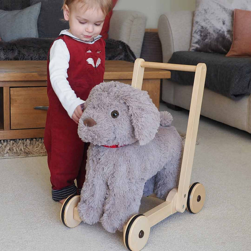 Toddler girl is excited when receiving her gift - the Little Bird Told Me Bailey Dog Push Along, Baby Walker and Ride On | Montessori Activities For Babies & Kids | Toys | Baby Shower, Birthday & Christmas Gifts - Clair de Lune UK