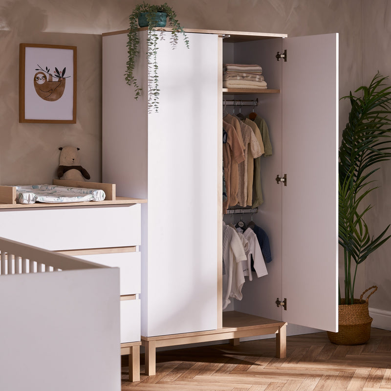 The wardrobe of the White and Natural Obaby Astrid Mini 3 Piece Room Set full with baby clothes in a Scandi Cashmere nursery room | Nursery Furniture Sets | Room Sets | Nursery Furniture - Clair de Lune UK