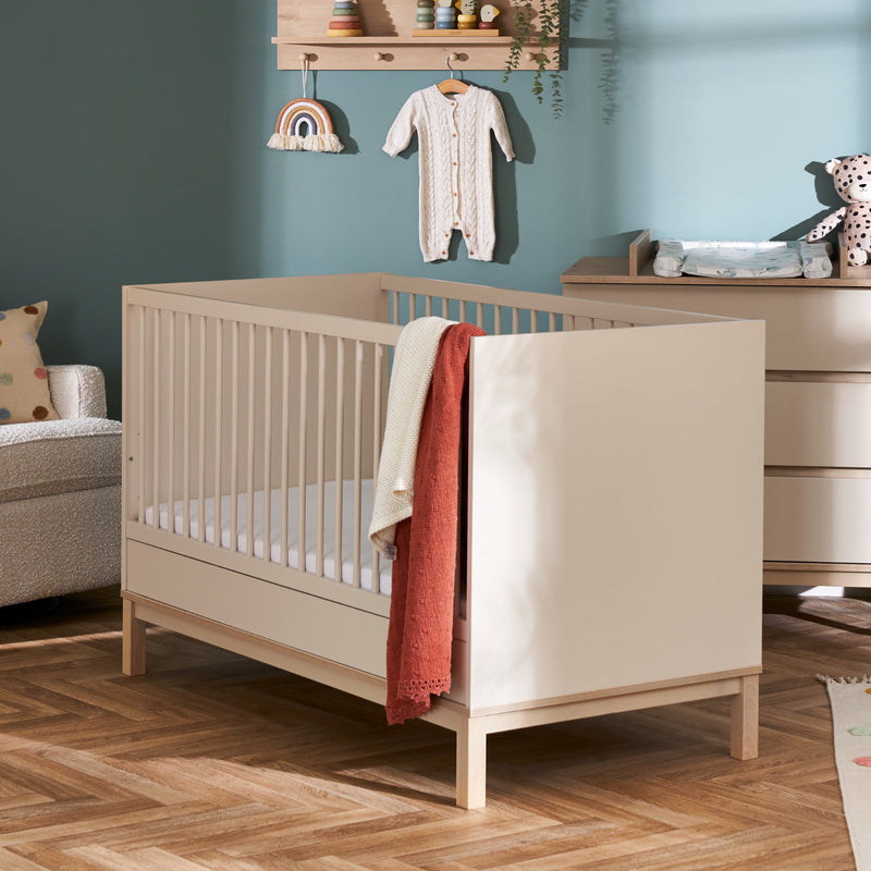 The Cashmere Natural Obaby Astrid Mini Cot Bed with a rust orange blanket on it for decoration in a pastel green Scandi jungle safari inspired nursery room | Cots, Cot Beds, Toddler & Kid Beds | Nursery Furniture - Clair de Lune UK