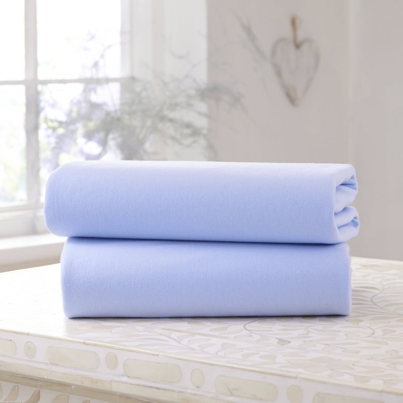 A Pack of 2 Folded Blue Fitted Cotton Moses Fitted Sheets - 74 x 30 cm on the countertop | Soft Baby Sheets | Cot, Cot Bed, Pram, Crib & Moses Basket Bedding - Clair de Lune UK