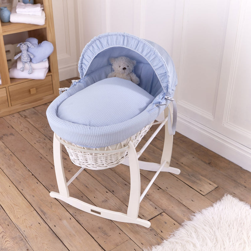 Blue Waffle White Wicker Moses Basket on the White Deluxe Rocking Stand in a minimalist bedroom | Co-sleepers | Nursery Furniture - Clair de Lune UK