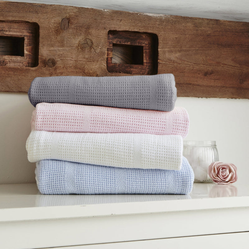 A stack of four Soft Cotton Cellular Pram Blankets in grey, pink, white and blue | Cosy Baby Blankets | Nursery Bedding | Newborn, Baby and Toddler Essentials - Clair de Lune UK
