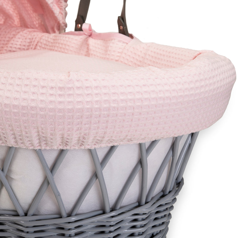 Pink Waffle Grey Wicker Moses Basket showing the sturdy vegan leather carry handle, matching bassinet dressing and coverlet made from super soft waffle fabrics | Moses Baskets | Co-sleepers | Nursery Furniture - Clair de Lune UK
