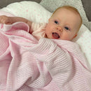 Happy baby swaddled up in the Pink Soft Cotton Cellular Shawl for a nap | Cosy Baby Blankets & Swaddles | Nursery Bedding | Newborn Baby Essentials - Clair de Lune UK