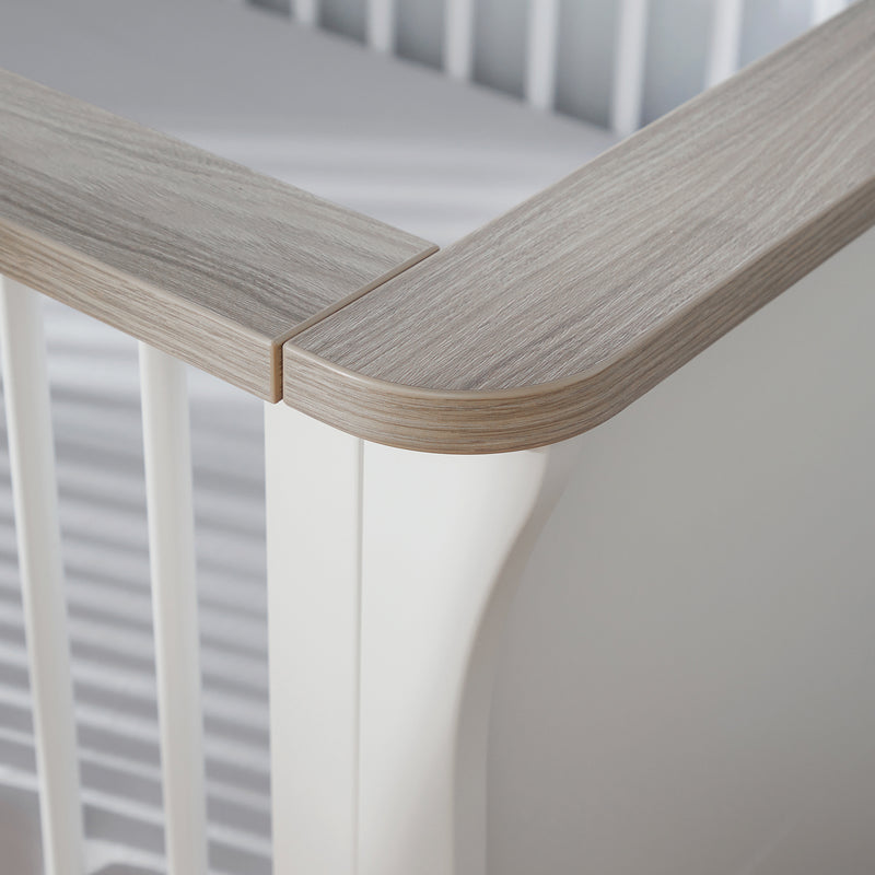 The natural wood details of the Natural Wood and White CuddleCo Clara Cot Bed in a white nursery | Cots, Cot Beds, Toddler & Kid Beds | Nursery Furniture - Clair de Lune UK