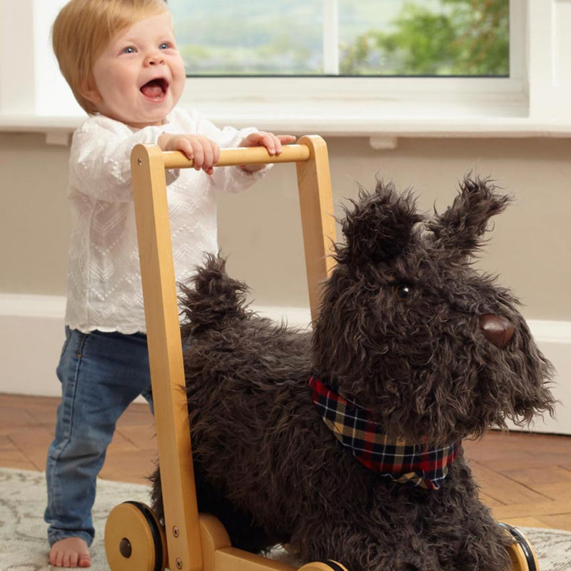 Toddler is laughing happily while practicing walking with the Little Bird Told Me Scottie Dog 2in1 Push Along, Baby Walker and Ride On | Baby Walkers and Ride On Toys | Montessori Activities For Babies & Kids | Toys | Baby Shower, Birthday & Christmas Gif