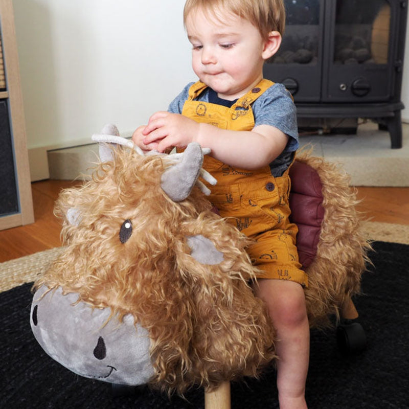 Little boy improving his sensory skills with the Little Bird Told Me Hubert Highland Cow Ride On Toy | Baby Walkers and Ride On Toys | Montessori Activities For Babies & Kids | Toys | Baby Shower, Birthday & Christmas Gifts - Clair de Lune UK