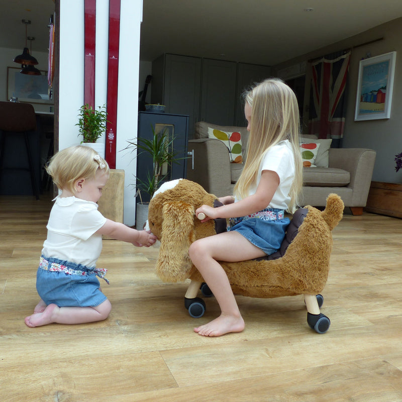 Kids playing with the Little Bird Told Me Peanut Pup Ride On Toy | Baby Walkers and Ride On Toys | Montessori Activities For Babies & Kids | Toys | Baby Shower, Birthday & Christmas Gifts - Clair de Lune UK