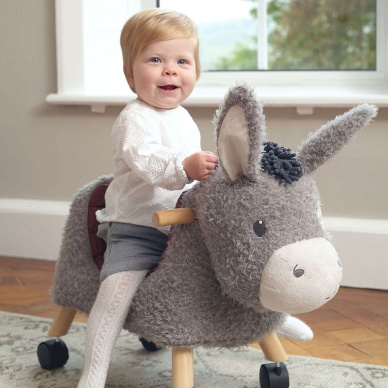 Toddler girl riding on her Little Bird Told Me Bojangles Donkey Ride On Toy | Baby Walkers and Ride On Toys | Montessori Activities For Babies & Kids | Toys | Baby Shower, Birthday & Christmas Gifts - Clair de Lune UK
