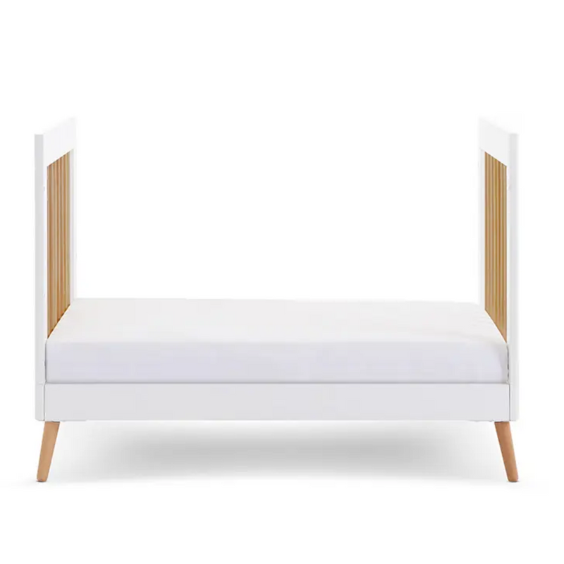 The front of the The white cot bed from the Obaby Maya Mini 2 Piece Room Set in white transformed to a white and natural toddler bed without side walls | Nursery Furniture Sets | Room Sets | Nursery Furniture - Clair de Lune UK