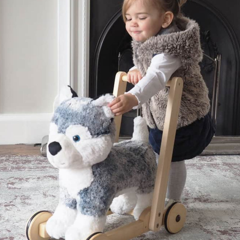 Little girl is touching the Mishka's super soft fur and enjoying pushing the Little Bird Told Me Mishka Dog 2in1 Push Along, Baby Walker and Ride On | Baby Walkers and Ride On Toys | Montessori Activities For Babies & Kids | Toys | Baby Shower, Birthday &
