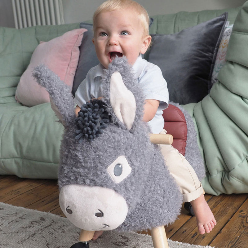 Toddler boy excited riding his Little Bird Told Me Bojangles Donkey Ride On Toy | Baby Walkers and Ride On Toys | Montessori Activities For Babies & Kids | Toys | Baby Shower, Birthday & Christmas Gifts - Clair de Lune UK