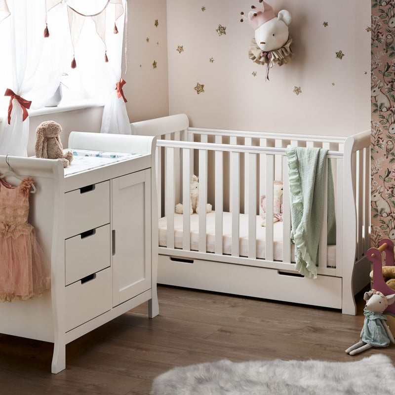 The white Obaby Stamford Mini Sleigh Cot & Changing Unit in a pink princess nursery room | Nursery Furniture Sets | Room Sets | Nursery Furniture - Clair de Lune UK