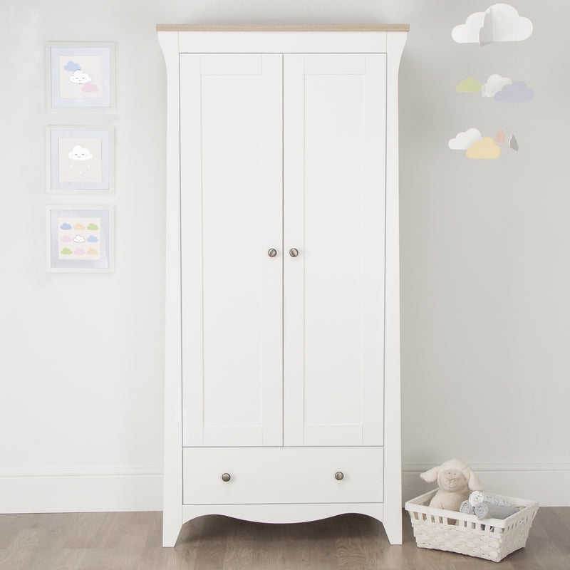 Closed White and Natural CuddleCo Clara 2 Door Double Wardrobe with baby clothes in front of a grey wall | Wardrobes & Shelves | Storage Solutions | Nursery Furniture - Clair de Lune UK