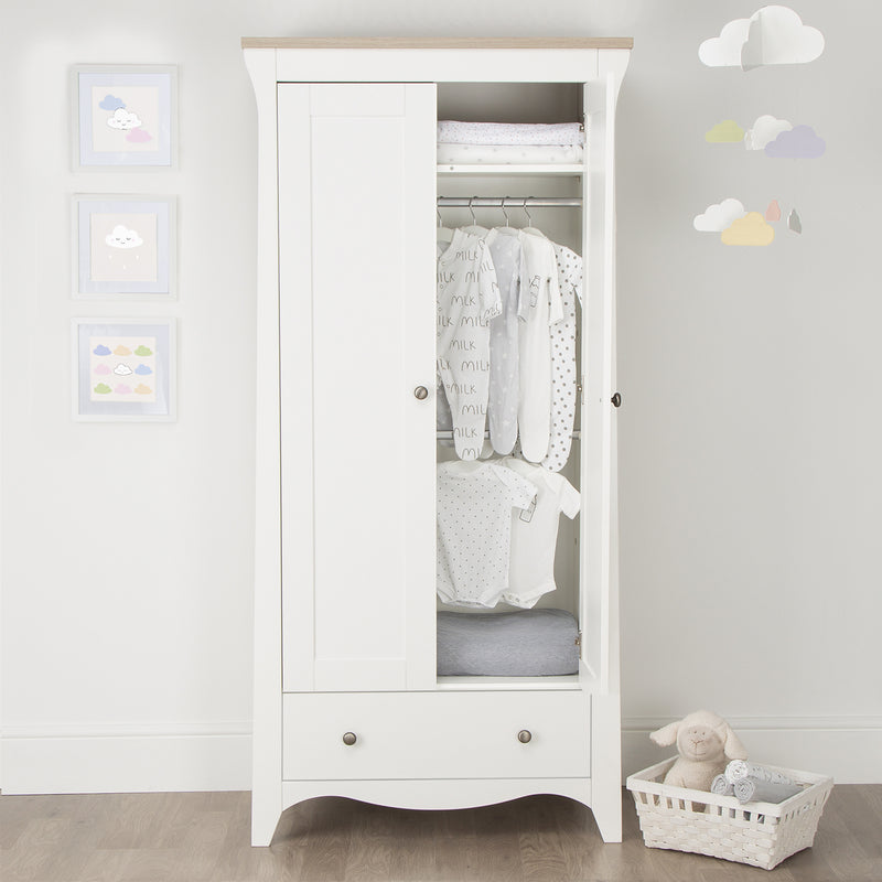 Open White and Natural CuddleCo Clara 2 Door Double Wardrobe with baby clothes in front of a grey wall | Wardrobes & Shelves | Storage Solutions | Nursery Furniture - Clair de Lune UK
