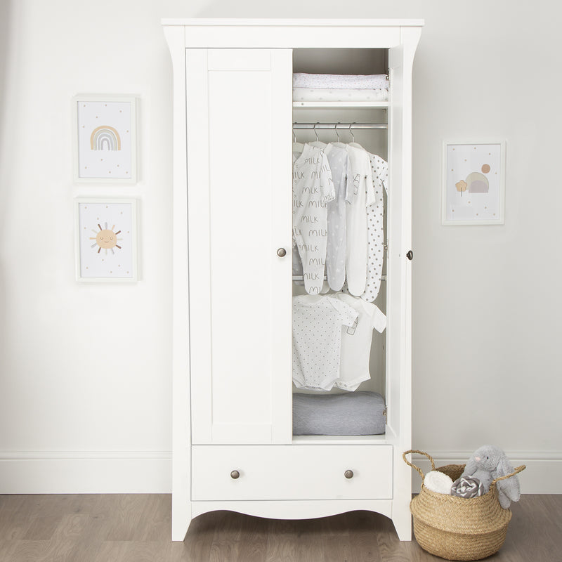 Open White CuddleCo Clara 2 Door Double Wardrobe with baby clothes in front of a grey wall | Wardrobes & Shelves | Storage Solutions | Nursery Furniture - Clair de Lune UK