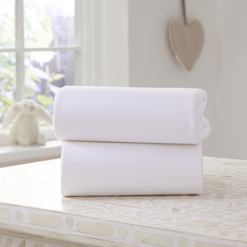 A Pack of 2 Folded White Fitted Cotton Moses Fitted Sheets - 74 x 30 cm on the countertop | Soft Baby Sheets | Cot, Cot Bed, Pram, Crib & Moses Basket Bedding - Clair de Lune UK