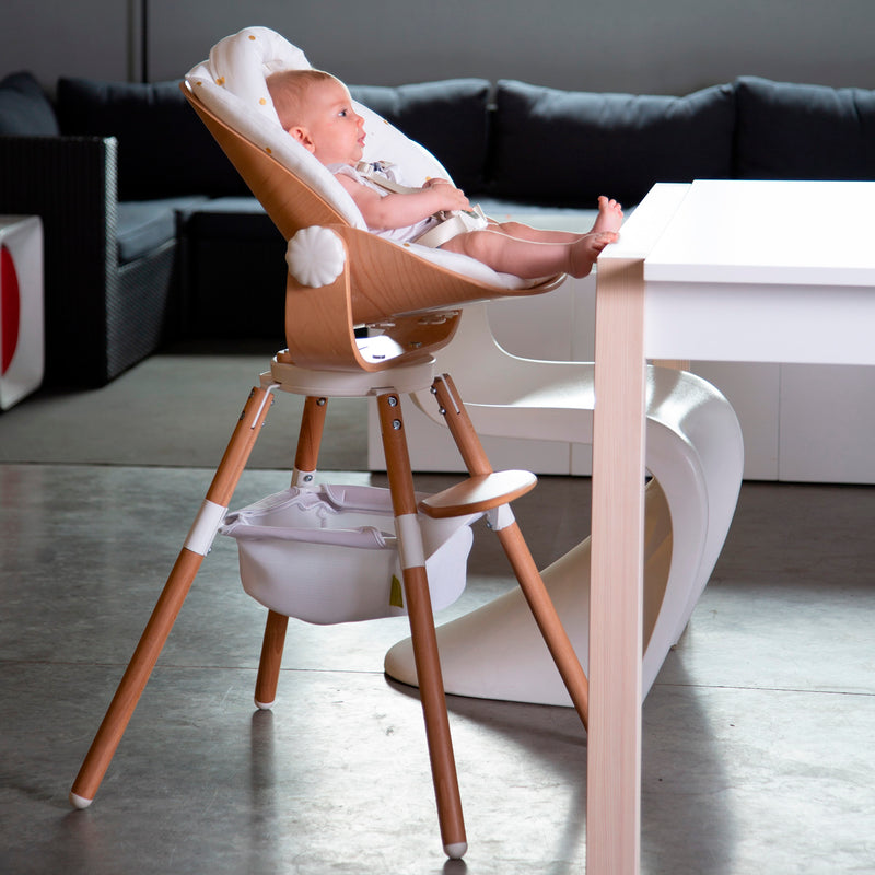 Baby sitting on the Natural/White Childhome Evolu Newborn Seat (For Evolu & One80°) to accompany his parents | Highchairs | Feeding & Weaning - Clair de Lune UK