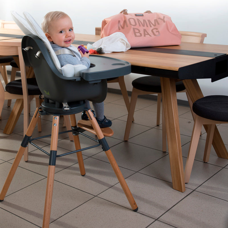 Baby sitting on the Natural/Anthracite Childhome Evolu 2 Chair - 2 In 1 with Bumper | Highchairs | Feeding & Weaning - Clair de Lune UK